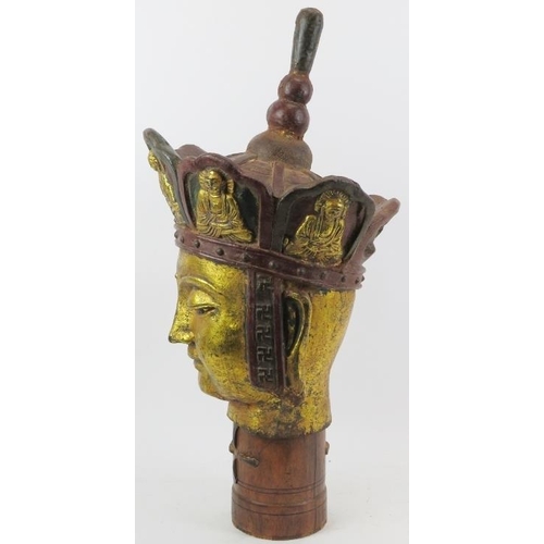 23 - A large Chinese gilt and lacquer painted bronze Buddha head. Supported on a cylindrical wood plinth.... 