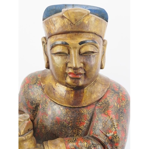 24 - A Chinese gilt and lacquer painted carved wood figure, 20th century. Supported on a rectangular wood... 