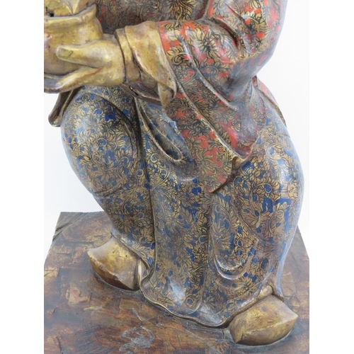 24 - A Chinese gilt and lacquer painted carved wood figure, 20th century. Supported on a rectangular wood... 