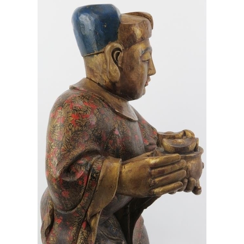 24 - A Chinese gilt and lacquer painted carved wood figure, 20th century. Supported on a rectangular wood... 