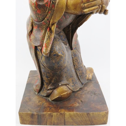 24 - A Chinese gilt and lacquer painted carved wood figure, 20th century. Supported on a rectangular wood... 