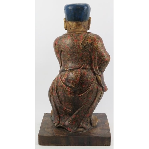 24 - A Chinese gilt and lacquer painted carved wood figure, 20th century. Supported on a rectangular wood... 