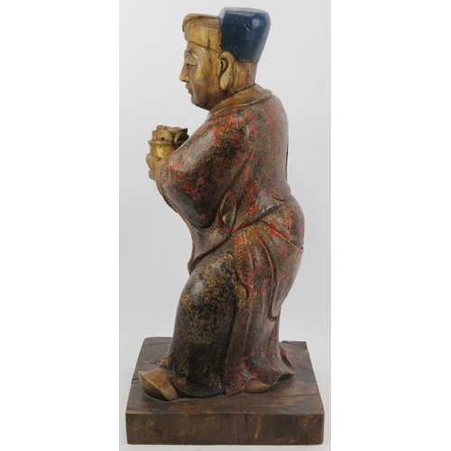 24 - A Chinese gilt and lacquer painted carved wood figure, 20th century. Supported on a rectangular wood... 