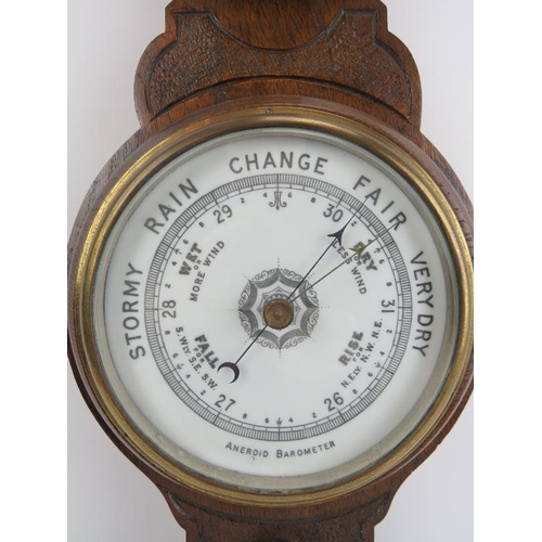 260 - A carved oak aneroid barometer, late 19th/early 20th century. Incorporated with a mercury thermomete... 