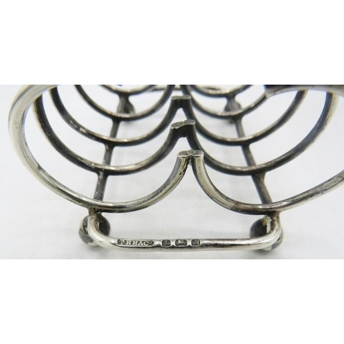 318 - A silver clover shaped four divisional toast rack on ball feet, Birmingham 1903 and a plated toast r... 