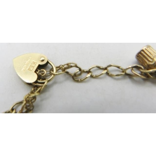 365 - A delicate unmarked yellow metal charm bracelet with 9ct gold padlock clasp and six charms, some mar... 