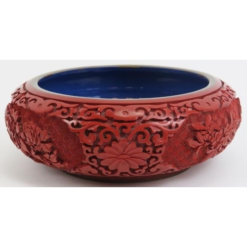 37 - A Chinese cinnabar lacquer bowl. With openwork carved wood stand. 7.5 in (19 cm) diameter. 
Conditio... 