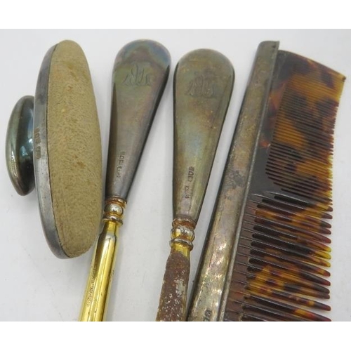 393 - A silver nail buffer, a silver backed comb and a pair of silver handles buttons hooks & shoe horn. A... 