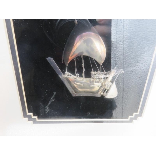 400A - A 925 stamped silver sailing boat in a box frame. Approx 11