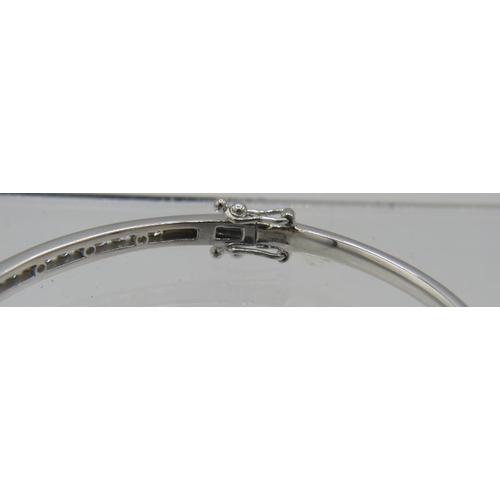 431 - An 18ct white gold bangle with one half set with a band of diamonds. Diamonds approx 1ct, double cli... 