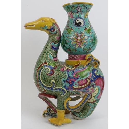 47 - A large Chinese polychrome enamelled porcelain duck, 20th century. Modelled as a duck carrying a vas... 