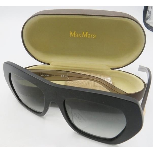 500D - A pair of Max Mara black sunglasses with gold coloured decoration on the transparent arms, cased.
Pr... 