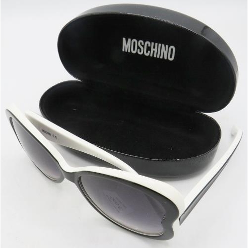 500E - A pair of black reverse heart sunglasses with white edging, cased.
Provenance: Part of a private col... 