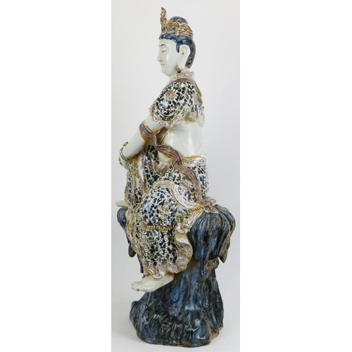 6 - A large Chinese figure of Guanyin, 20th century. depicted seated on a rock with the figure painted i... 