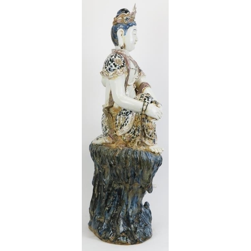 6 - A large Chinese figure of Guanyin, 20th century. depicted seated on a rock with the figure painted i... 