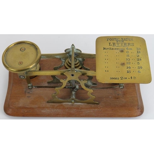 85 - A set of brass postal scales and weights. One tray inscribed with a postal rates list for letters. S... 