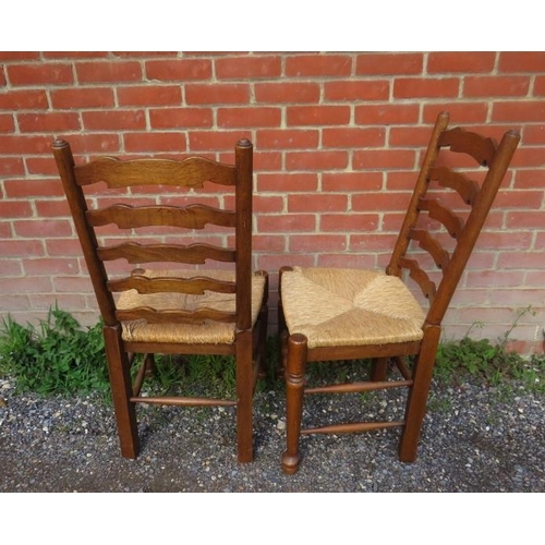 875 - A set of eight vintage oak Lancashire ladder-back dining chairs with rush seats, on turned supports ... 