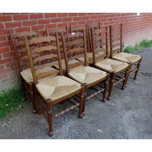 875 - A set of eight vintage oak Lancashire ladder-back dining chairs with rush seats, on turned supports ... 