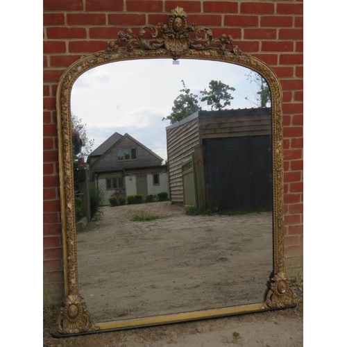 705 - A large Victorian arched over-mantle mirror, the gilt gesso frame with shell cornice amidst scrollin... 