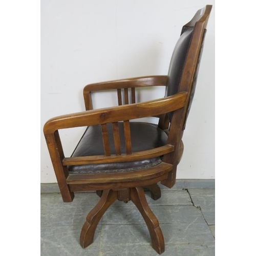 709 - An Edwardian walnut swivel height adjustable captain’s desk chair, upholstered in black leather with... 