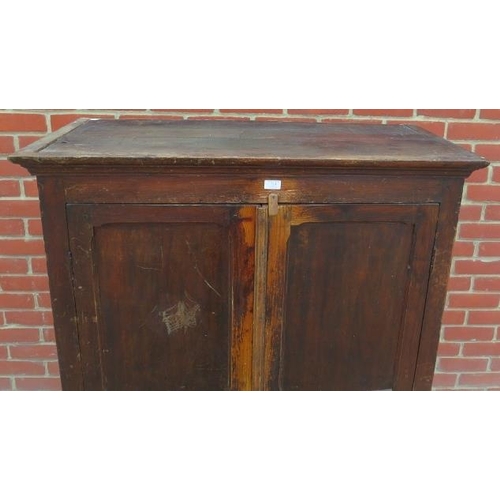 713 - An 18th century pine bacon/pantry cupboard, the panelled doors opening onto hanging rails above two ... 