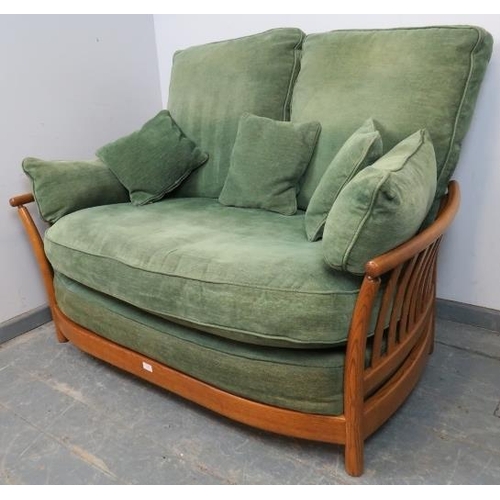 720 - A contemporary ash two-seater sofa by Ercol, with loose cushions in green and matching scatter cushi... 