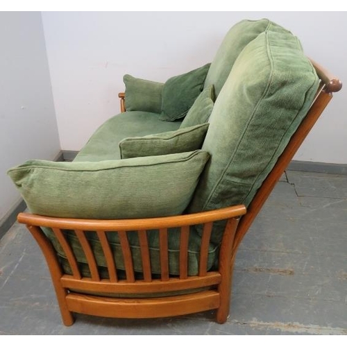 720 - A contemporary ash two-seater sofa by Ercol, with loose cushions in green and matching scatter cushi... 