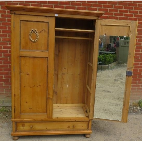 723 - An antique Continental pine double wardrobe, the panelled doors opening onto a loose shelf above a h... 