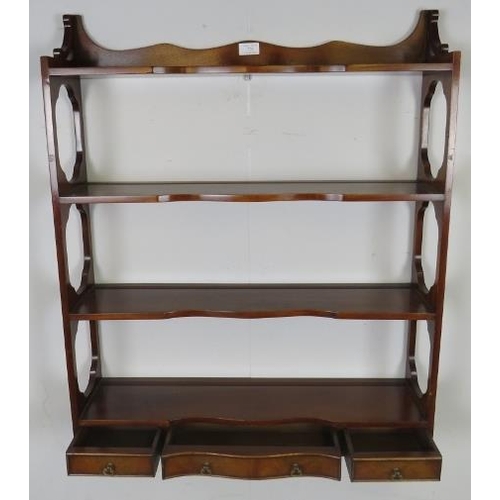 725 - A set of reproduction mahogany serpentine fronted wall-hanging shelves in the Georgian taste, with t... 