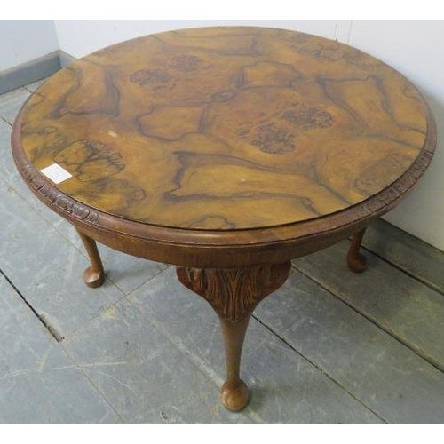 731 - A 1920s figured walnut low circular coffee table, on acanthus carved cabriole supports with pad feet... 