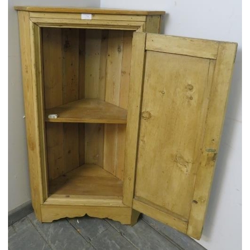 739 - An antique stripped pine floor standing corner cupboard, the panelled door opening onto one fitted s... 