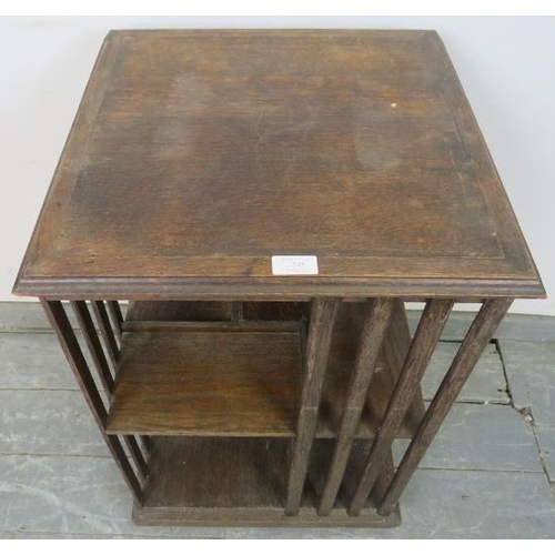 745 - An Edwardian oak revolving book table of eight open shelves, with crossbanded top and slatted sides,... 