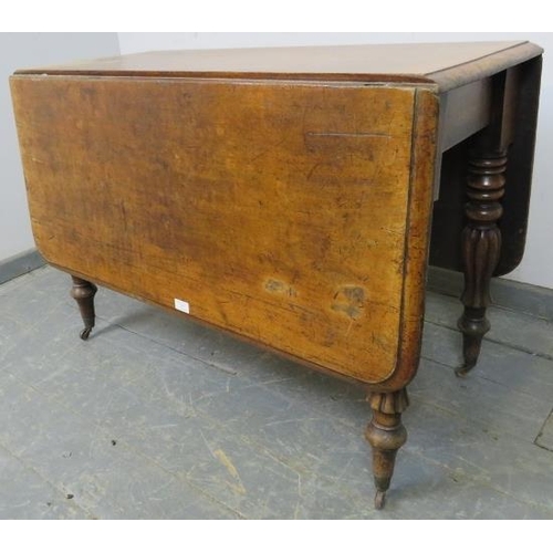 757 - A Victorian walnut drop-leaf table, on tapering turned and fluted supports with brass caps and casto... 