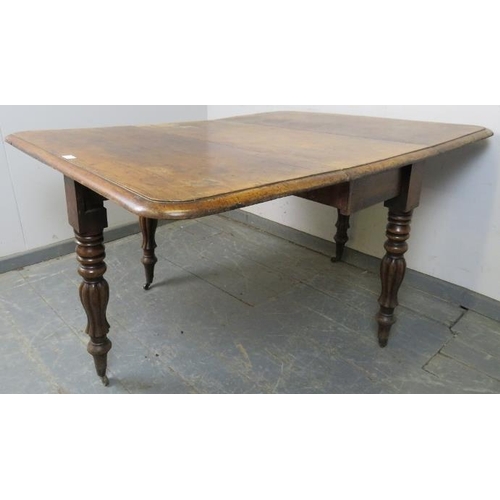 757 - A Victorian walnut drop-leaf table, on tapering turned and fluted supports with brass caps and casto... 