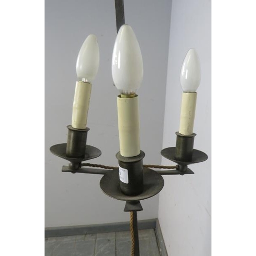 831 - A vintage wrought iron height adjustable standard lamp in the Gothic taste, with top finial and thre... 