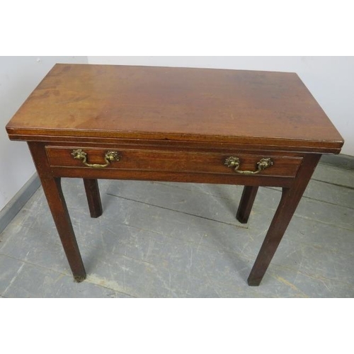 859 - A Georgian mahogany turnover tea table, housing one long drawer with fancy brass swan-neck handles, ... 