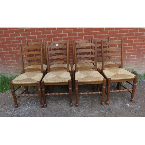 875 - A set of eight vintage oak Lancashire ladder-back dining chairs with rush seats, on turned supports ... 