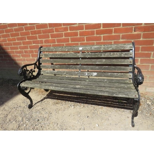 885 - A weathered cast iron scroll back garden bench with teak slatted seat, on pierced end supports with ... 