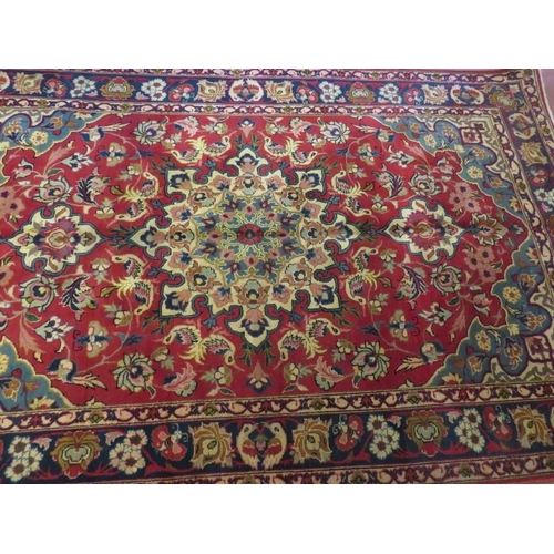 908 - A fine central Persian Isfahan rug, central patterned motif on red ground and blue spandrels. 250 x ... 