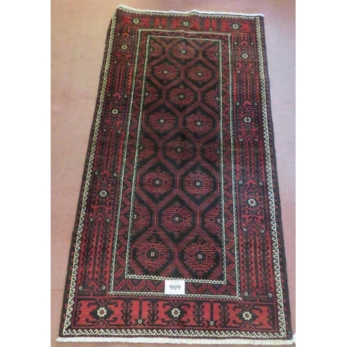 909 - A North East Persian meshed Belouch rug deep burgundy high lighted with black and white. In good con... 