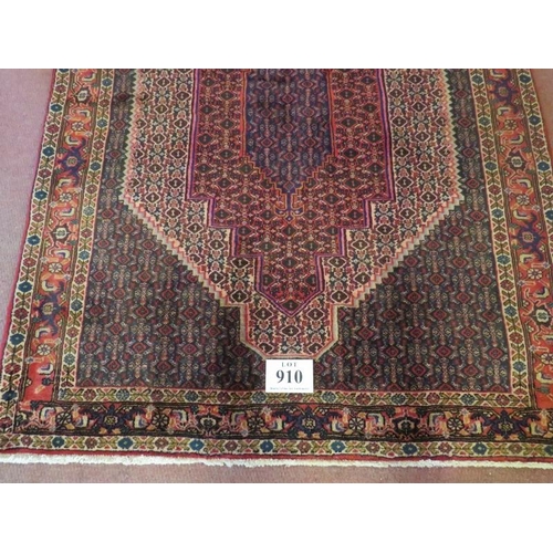 910 - A North West Persian Senneh rug central 3 level motif on a repeat pattern ground. In good condition.... 