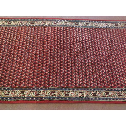 914 - North East Persian Mir runner central repeat pattern field on red ground and in good condition. 3.80... 