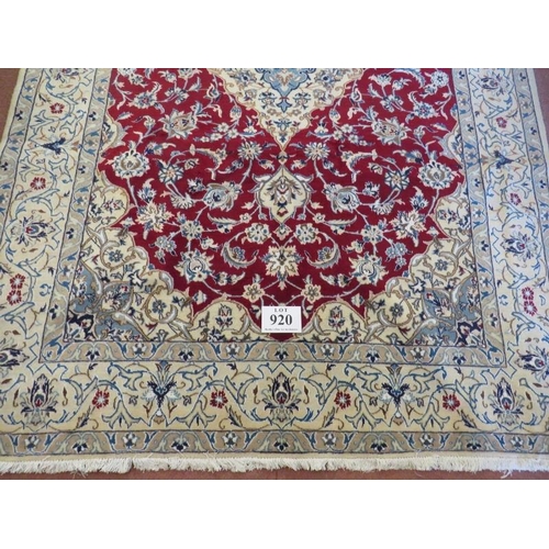 920 - A Persian meshed rug, central cream floral motif on a red ground and cream borders. 255 x 165.