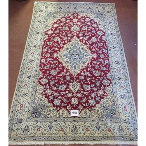 920 - A Persian meshed rug, central cream floral motif on a red ground and cream borders. 255 x 165.