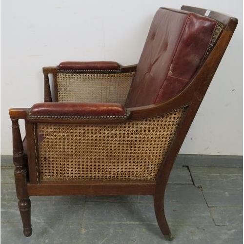 842 - An Regency Period bergère library chair, with loose cushions upholstered in oxblood buttoned leather... 