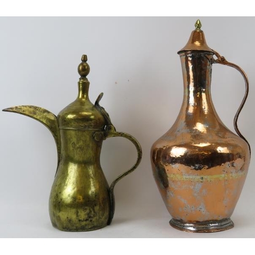 221 - Two Middle Eastern metalwork decanters. Comprising a copper jug with hinged cover together with a br... 