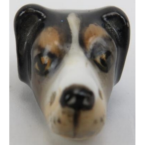 124 - A Royal Worcester dogs head whistle. The hunting dog with painted features and Royal Worcester puce ... 