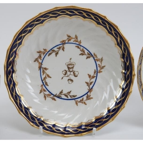 15 - Two Worcester gilt blue and white porcelain teacups and saucers, early 19th century. With a raised s... 