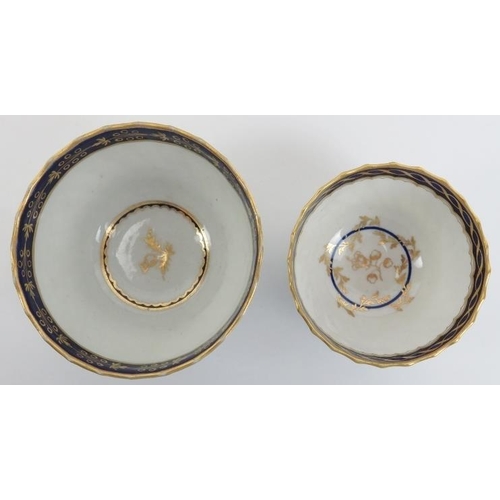 15 - Two Worcester gilt blue and white porcelain teacups and saucers, early 19th century. With a raised s... 