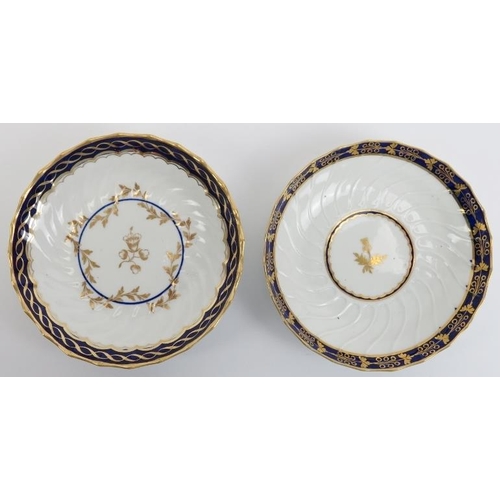 15 - Two Worcester gilt blue and white porcelain teacups and saucers, early 19th century. With a raised s... 